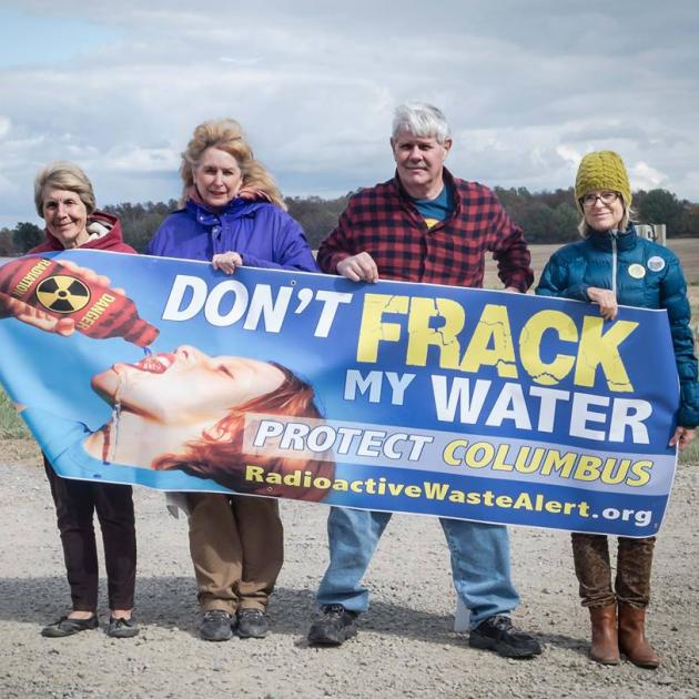 Four people holding a Don't Frack My Water sign