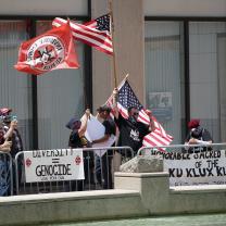 Guys waving flags and with Ku Klux Klan signs