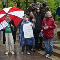 People in rain with signs touting the importance of facts