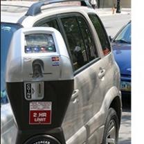 Close up of a parking meter and cars parked behind it