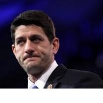 Blue background and head and shoulders of white man with black hair biting him lips as if he's upset