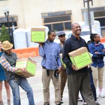 Many people holding boxes