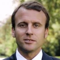 Young looking man with brown hair receding hairline against trees in background