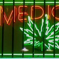 Neon sign glowing in window orange letters saying Medical and Green image of a marijuana leaf