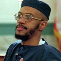 Black man  with wire-rimmed glasses and a mustache and beard